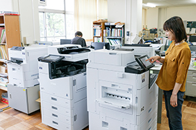 職員室の中央にLX-10050MF×2台、PX-S7090X×1台を設置、PCから直接印刷
