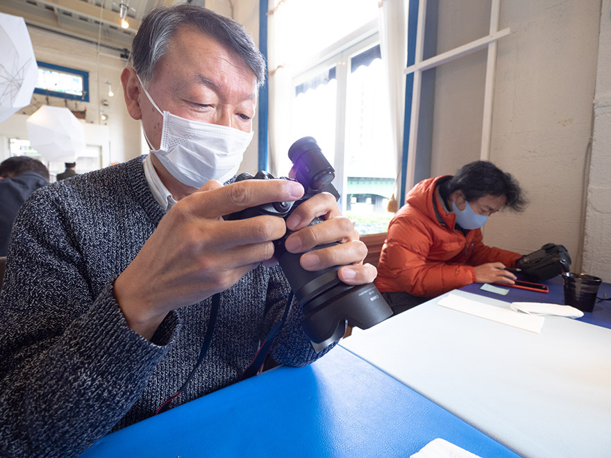 たくさんの写真の中から、真剣なまなざしでプリントするための作品を選び出す