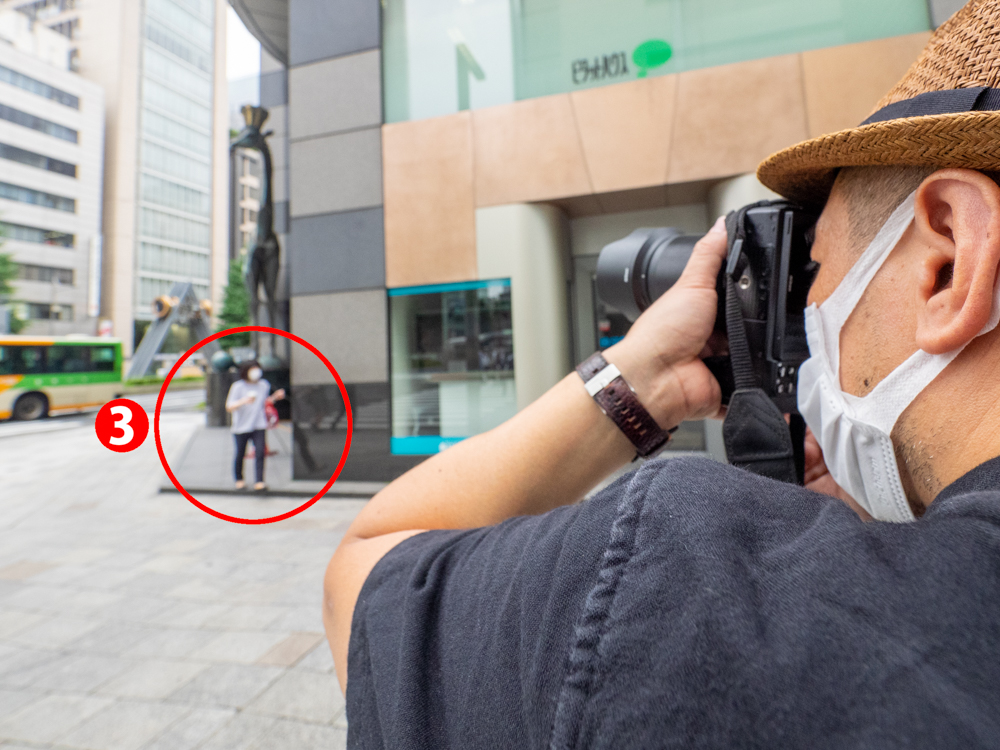 熊切さんならどうするのかというと、構図を決めて待ち構え、（3）通行人が重なった瞬間にシャッターを切る。これで、作品の印象を壊しかねない赤いコーンが排除できる。