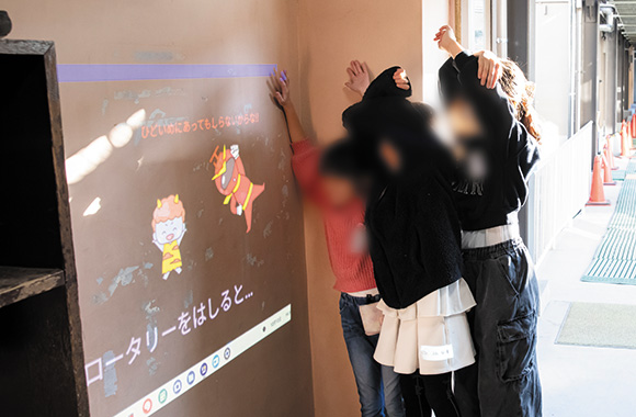 プログラマッピングに取り組む子供たち 鬼のキャラクターが壁に映し出される様子