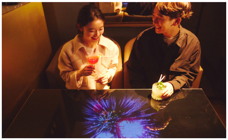 テーブルにプロジェクターの映像が投影される、バーラウンジの個室