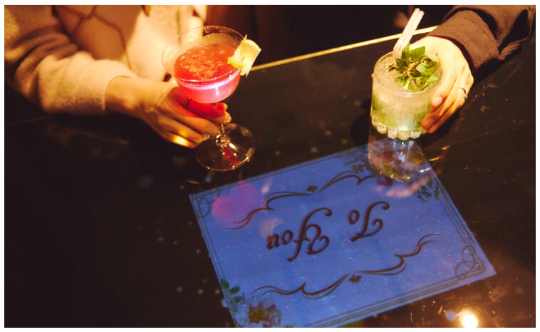 テーブルにプロジェクターの映像が投影される、バーラウンジの個室